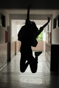 School child silhouette jumping for joy
