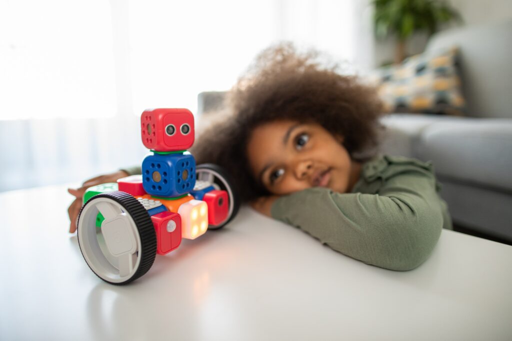 Ein Mädchen spielt mit einem Baukasten-Roboter
